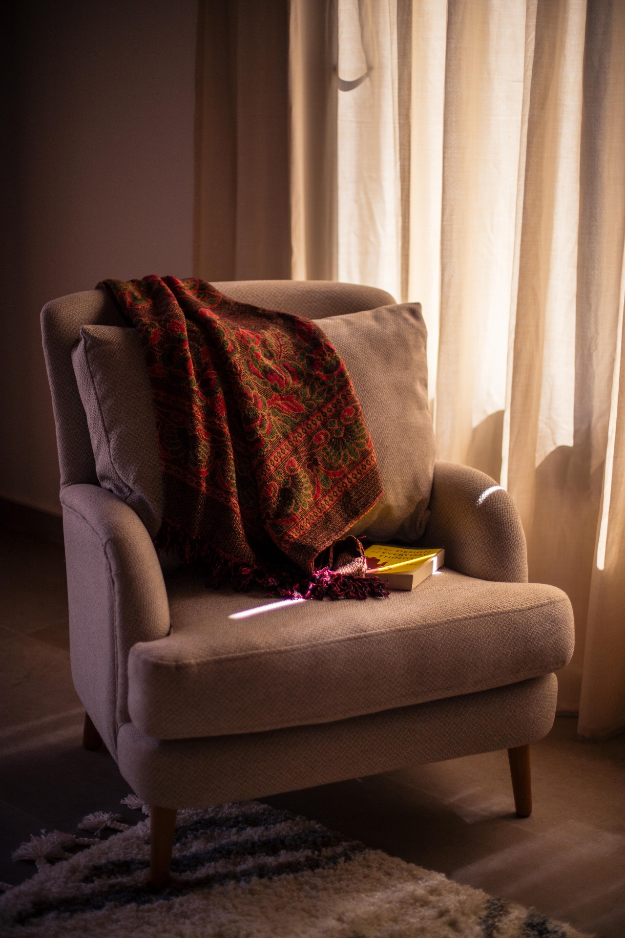 Cozy reading chair with traditional blanket and warm lighting